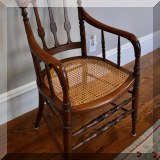 F42. Wooden arm chair with caned seat. 35”h x 21”w x 18”d - $145 